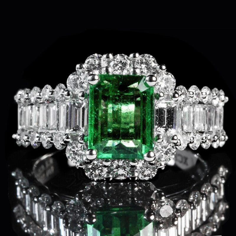 An emerald-and-diamond halo engagement ring