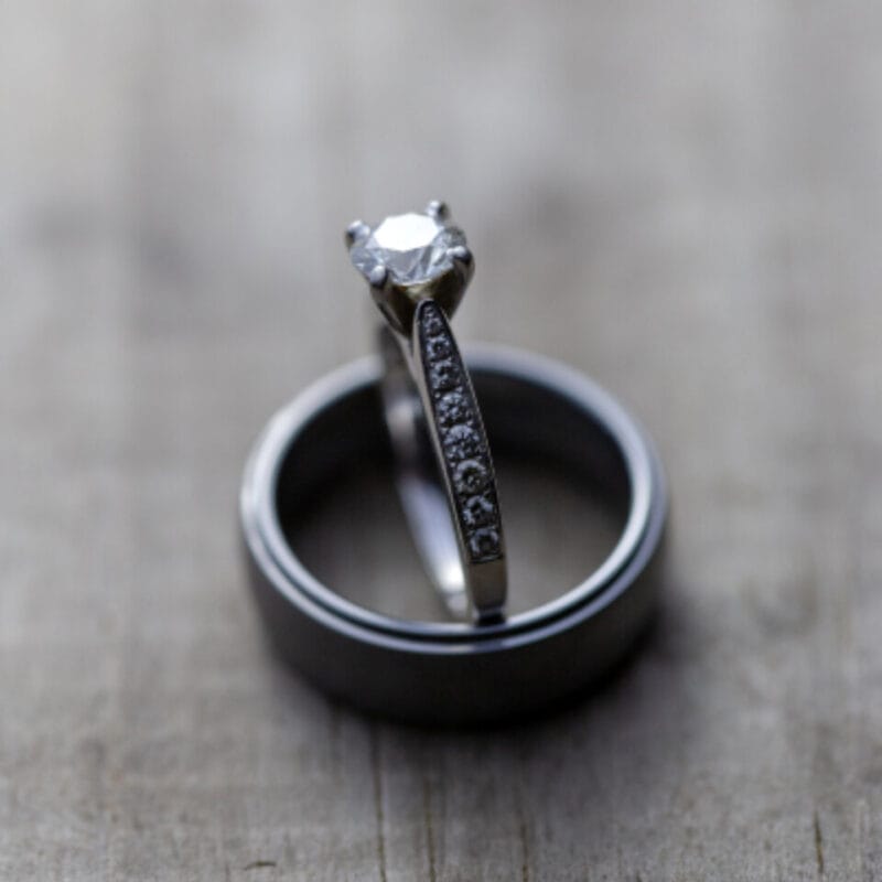 A diamond engagement ring displayed on a stand