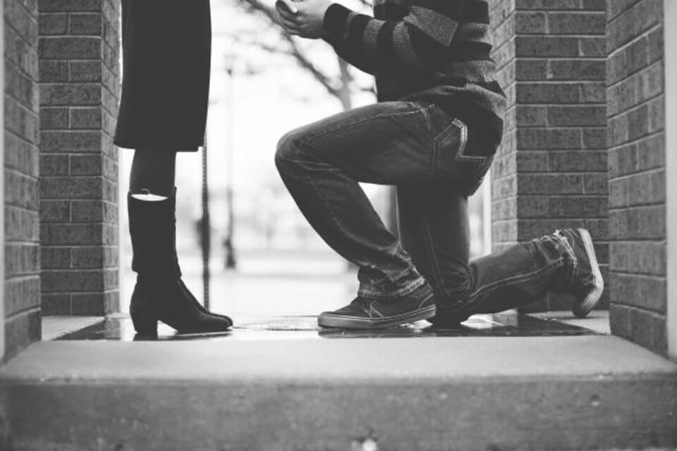 A marriage proposal — kneeling with a diamond engagement ring