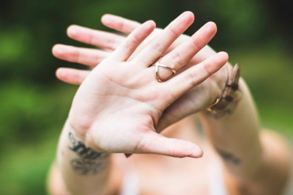 Hands clasped together showing a diamond engagement ring